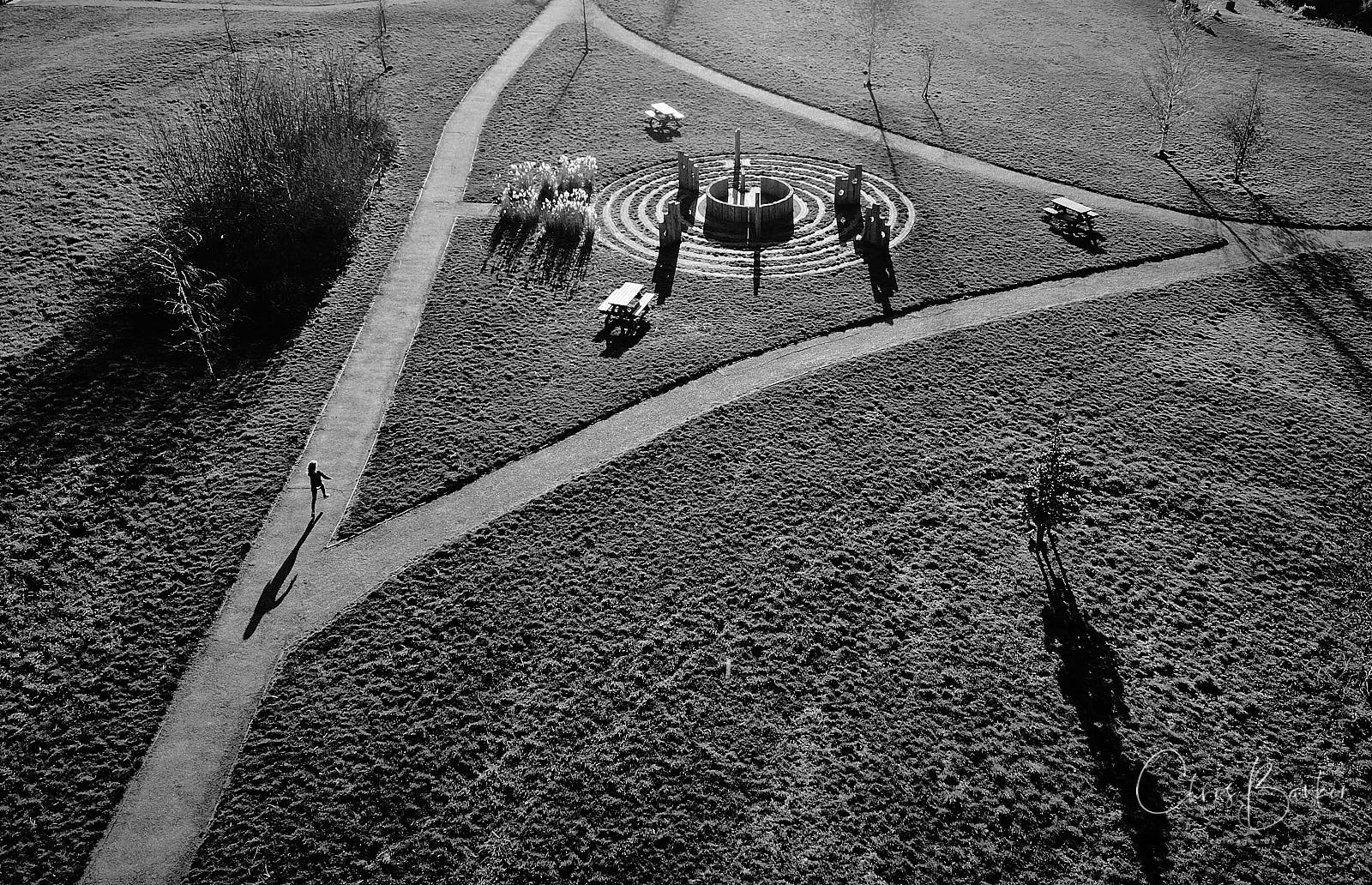 A monochrome photo of a girl and her shadow on the path of Millbridge Meadows in Gamlingay